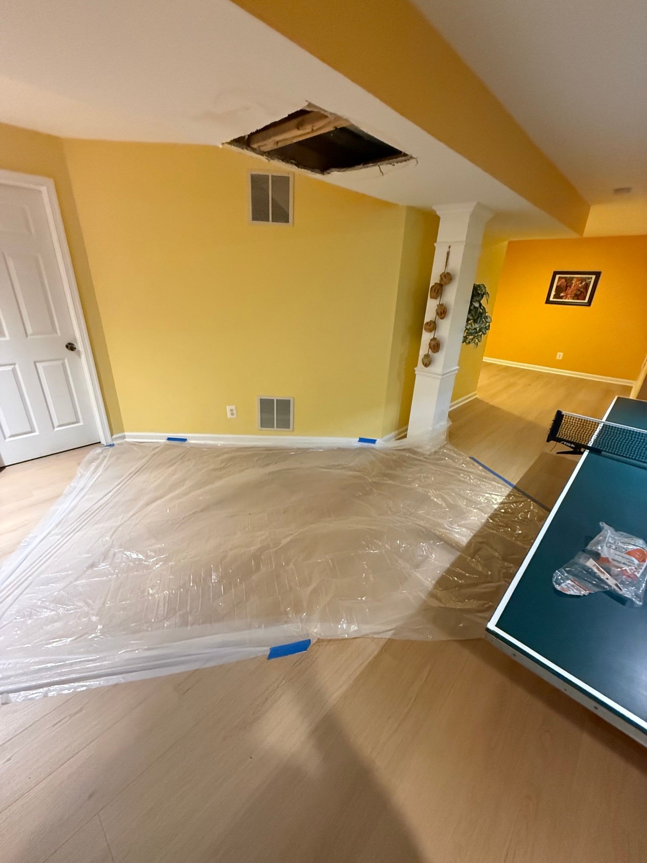 Ceiling hole cut open with joist exposed before repair
