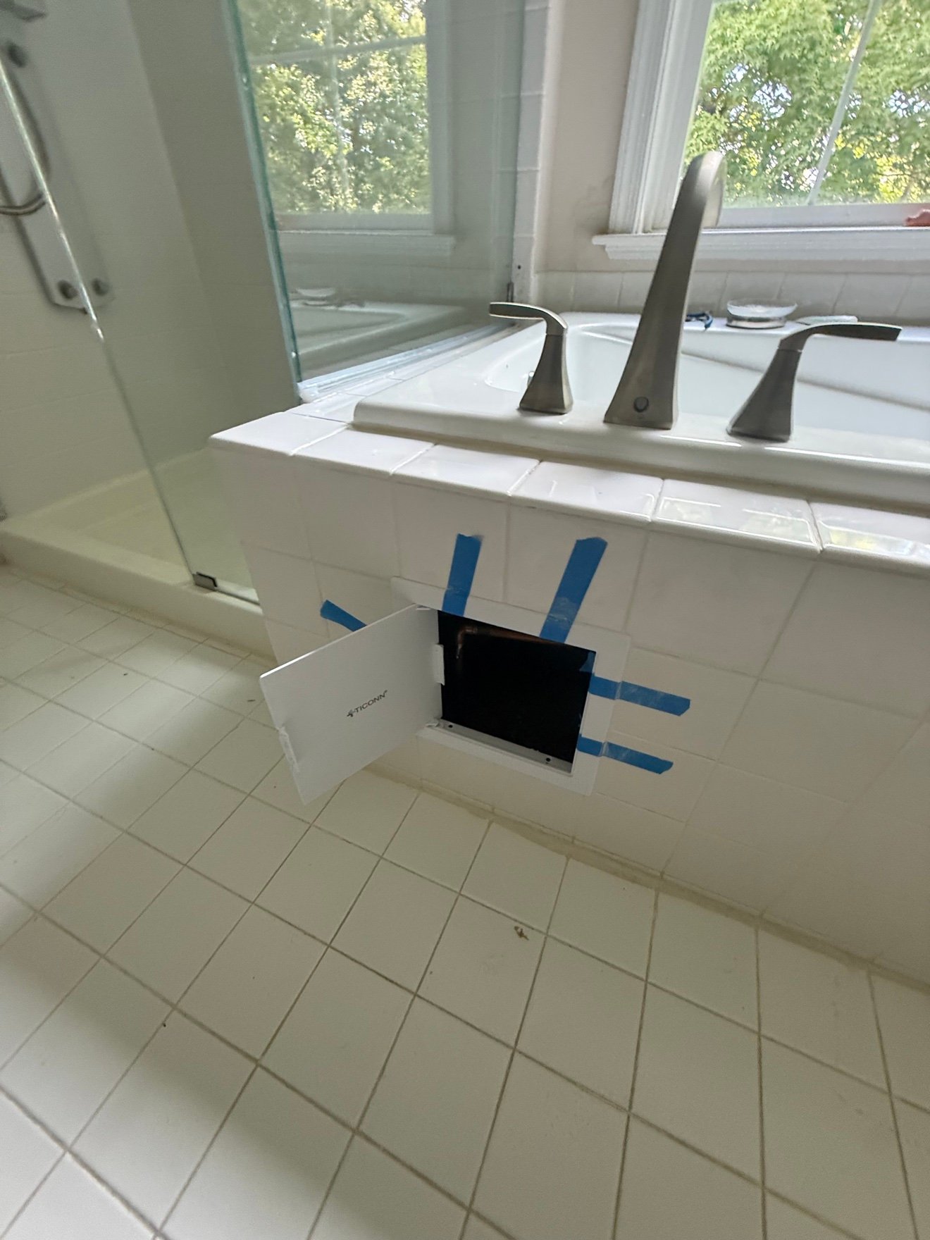 Bathtub with faucet access panel opened